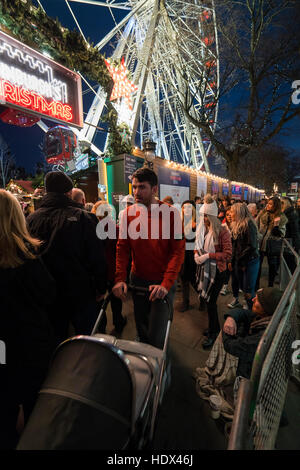 Schottland - Weihnachtsmarkt, Princes Street, Edinburgh Weihnachten Tourismus. Riesenrad in Fair. Eingang, Obdachloser. Stockfoto