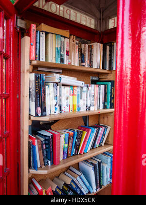 Telefonbox, die als Bibliothek im Dorf Bosham, West Sussex, England, genutzt wird. Stockfoto