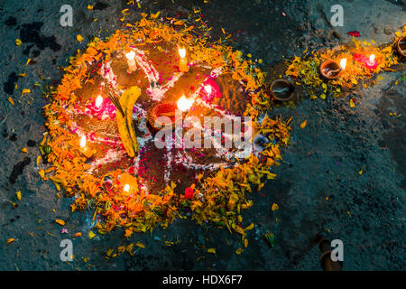 Ein buntes Mandala besteht aus Colorpowder und Kerzen für das Tihar-festival Stockfoto