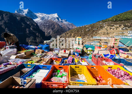 Die Waren werden im wöchentlichen lokalen Markt in Namche Bazar verkauft, der Berg kongde (6086 m) in der Ferne. Stockfoto