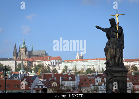 Die Statue von Johannes dem Täufer auf der Karlsbrücke, Prag, weist den Weg zur Prager Burg Stockfoto