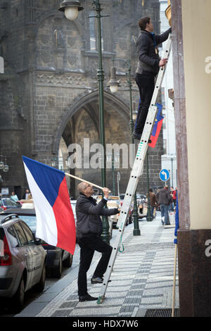 Bereiten Sie zwei Männer zu setzen, eine tschechische Flagge auf einer Straße in der Nähe der mittelalterlichen Pulverturm in Prag Stockfoto