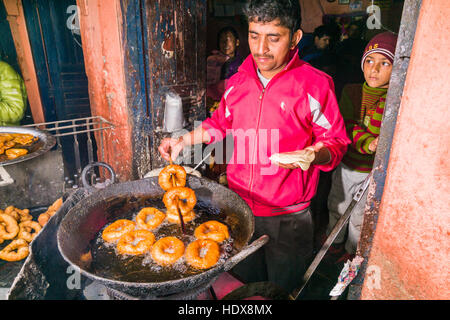 Ein Mann ist braten Donuts, typisch nepalesischen Frühstück, das in einem großen Topf Stockfoto