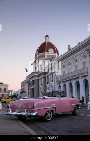 Rosa, oben offen, Cabriolet, amerikanische Oldtimer vor der gewölbte Palacio de Gobierno, am Parque Jose Marti, Cienfuegos, Kuba Stockfoto