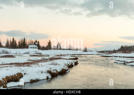 Der Thingvellir Kirche in einer Lagune von schmelzendem Schnee und Flüsse konvergierende im Fluss und See Thingvallavatn, Island. Stockfoto