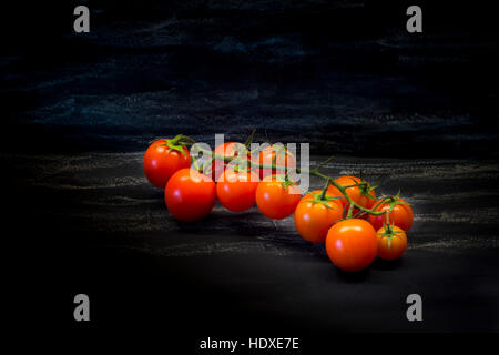 Cherry-Tomaten auf schwarzem Hintergrund. Gesunde Ernährung, vegetarische Konzept. Bio-Lebensmittel. Stockfoto