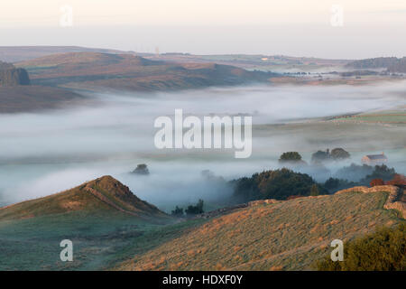 Tiefliegende Nebel im Morgengrauen verdunkelt, Cawfield Steinbruch und Haltwhistle Common - gesehen von Cawfield Klippen, Hadrianswall Stockfoto