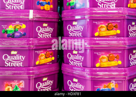 Gestapelte Dosen Quality Street Pralinen warten zu Weihnachten verkauft werden. Stockfoto
