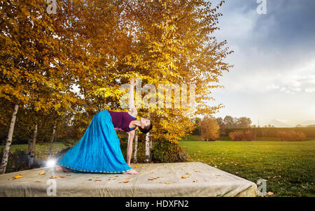 Junge Frau beim Yoga im Herbst Stadtpark in der Nähe von Birken gelb Stockfoto