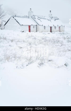 Schnee bedeckt traditionelle Hütte im Schnee im Winter bedeckt, in den schottischen highlands Stockfoto