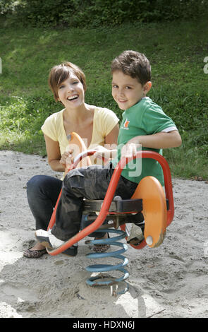 Junge Mutter und Sohn, Kind auf Spielplatz Stockfoto