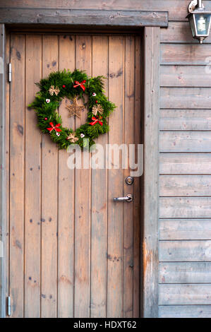 Weihnachts-Dekorationen auf eine Holztür Stockfoto