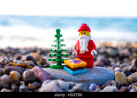 Paphos, Zypern - 20. November 2016 Lego Santa Claus mit Weihnachtsbaum und gegenwärtigen Stand auf Pebble beach gegen Meer. Stockfoto