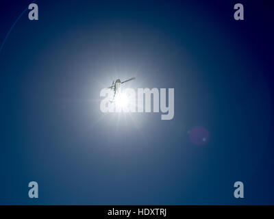 Anschauen der Sonne, in einem klaren, blauen Himmel, als Tour-Helikopter fliegt über Kopf. Stockfoto