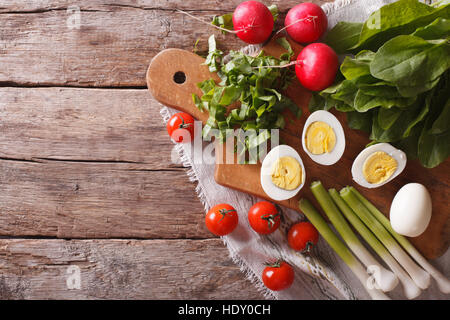 Zutaten für Frühlingssalat: Eiern, Tomaten, Radieschen, Sauerampfer. horizontale Ansicht von oben Stockfoto