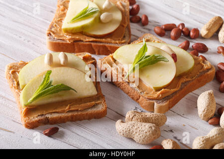 süßer Toast mit frischen Apfel und Erdnussbutter auf dem Tisch. Horizontale Stockfoto