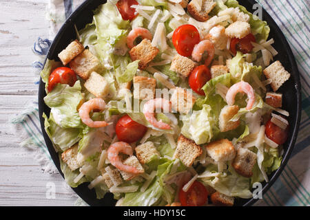 Köstliche Caesar-Salat mit Garnelen Nahaufnahme auf einer schwarzen Platte. horizontale Ansicht von oben Stockfoto