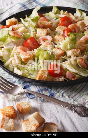 Caesar Salat mit Meeresfrüchten und Tomaten-close-up auf einem Teller. Vertikal Stockfoto