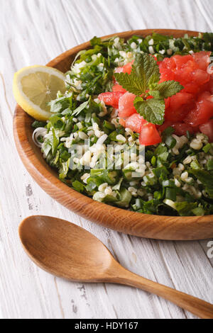 Taboulé Salat Closeup in einer Holzschale auf dem Tisch. vertikale Stockfoto