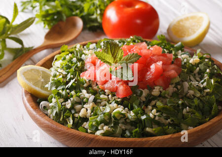 Vegetarischer Salat Taboulé hautnah in einer Holzschale und Zutaten. horizontale Stockfoto