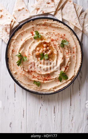 Klassische Hummus mit Petersilie auf den Teller und Pita Brot. vertikale Ansicht von oben Stockfoto