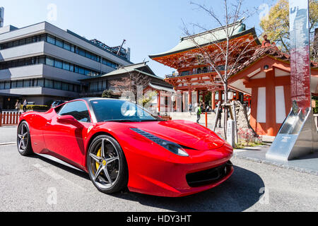 Roten Ferrari 458 Italia in der Nähe von Vermillion zwei geparkte - Geschichte Romon Tor der beliebten Ikuta Shinto Schrein n Kobe, Japan. Strahlender Sonnenschein, blauer Himmel. Stockfoto