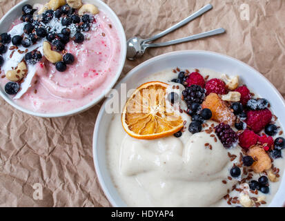 Smoothie-Schüssel, Bananen-Eis mit Beeren, Nüssen, Flachs. Perfekt für die Detox-Diät oder einfach nur eine gesunde Mahlzeit.  Liebe für eine gesunde Rohkost-Konzept. Stockfoto