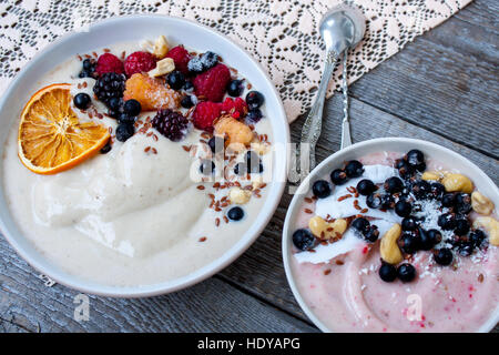 Smoothie-Schüssel, Bananen-Eis mit Beeren, Nüssen, Flachs. Perfekt für die Detox-Diät oder einfach nur eine gesunde Mahlzeit.  Liebe für eine gesunde Rohkost-Konzept. Stockfoto