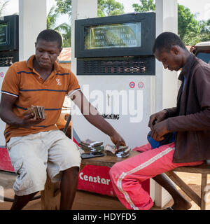 Heftklammern von Geld an einer Tankstelle in Sierra Leone Stockfoto