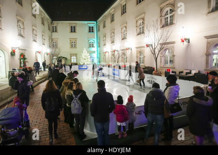 Menschen-Eislaufen im Eisstadion Synthethic in der verzierten Art Gallery Klovicevi Dvori in der oberen Altstadt in Zagreb, Kroatien Stockfoto