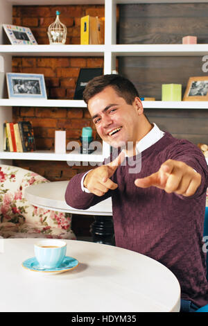 Junge Mann lächelte und deutete auf Sie mit beiden Händen Stockfoto