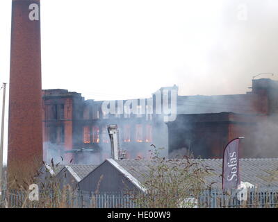 Oldham, Großbritannien. 15. Dezember 2016. Notdienste haben mehr als 100 Unterkünfte in der Nähe evakuiert, nach einem großen Feuer an einem Papier-Mühle-Standort in Greater Manchester brach. Mehr als 70 Feuerwehrleute und 15 Feuerwehrautos aus größeren Manchester Feuer und Rettung Service wird das Feuer auf das Gebäude in Cardwell Straße in Oldham, Nord-östlich von Manchester, am Donnerstagmorgen angegangen. © M Kyle/Alamy Live-Nachrichten Stockfoto