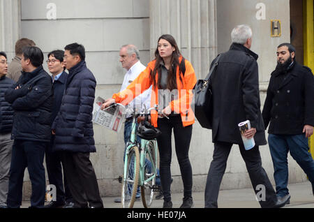 London, UK, 16.12.2016, schiebt eine Frau ihr Fahrrad über die Kreuzung als Fahrt durch es.  Die City of London Corporation hat angekündigt, dass Autos, Taxis und LKWs an Wochentagen von 07:00 bis 19:00 von der belebten Kreuzung für einen 18-Monats-Testversion verboten werden. Nur Busse, Radfahrer und Fußgänger dürfen. Vorausgegangen war den Tod eines Radfahrers Ying Tao. Stockfoto