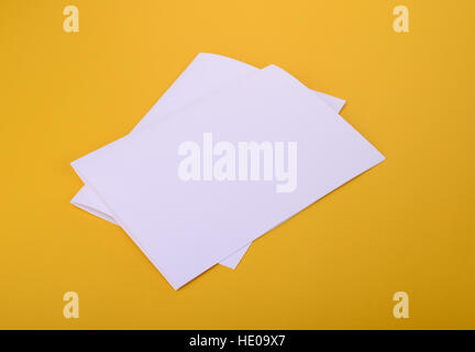 zwei weiße Papier Bifold Broschüre Mockup auf gelbem Hintergrund Stockfoto