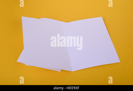zwei weiße Papier Bifold Broschüre Mockup auf gelbem Hintergrund Stockfoto