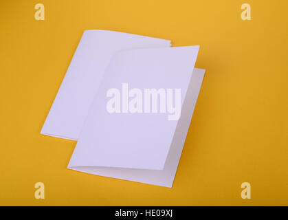 zwei weiße Papier Bifold Broschüre Mockup auf gelbem Hintergrund Stockfoto