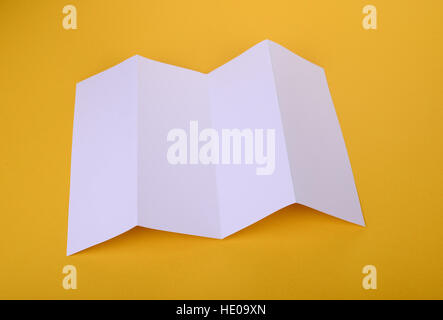 Weißbuch vierfach Broschüre Mock-up auf gelbem Hintergrund Stockfoto