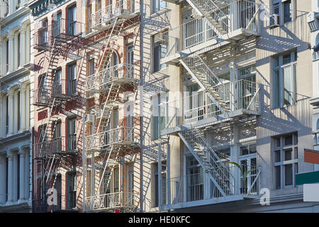 Häuser-Fassaden mit Feuerleiter Treppen Hintergrund, sonnigen Morgen in Soho, New York Stockfoto