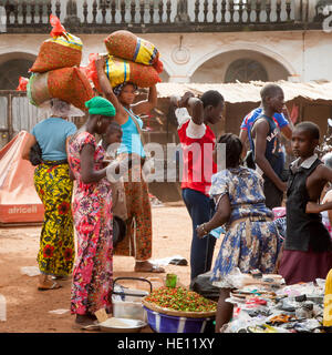 Markt in Makeni, Sierra Leone. Tüten mit Paprika sind nicht schwer, aber eine Schicht Plastikfolie auf dem Kopf hat sich gegen die Schärfe der Paprika als wirksam erwiesen Stockfoto