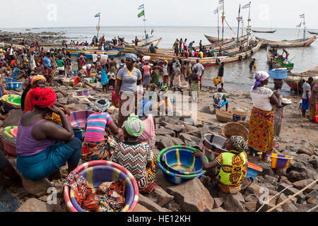 Viel Verkehr am Strand in Tombo Harbour, Sierra Leone. Die Frauen warten auf weitere Fischerboote. Der einzige weiße Mann auf diesem Bild: Christiano Ronaldo (CR7), isoliert von den anderen, auf einem T-Shirt gedruckt Stockfoto