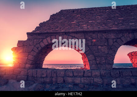 Überreste der alten römischen Wasserleitung in antiken Stadt Caesarea bei Sonnenuntergang. Israel. Stockfoto