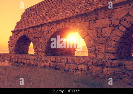 Überreste der alten römischen Wasserleitung in antiken Stadt Caesarea bei Sonnenuntergang. Israel. Stockfoto