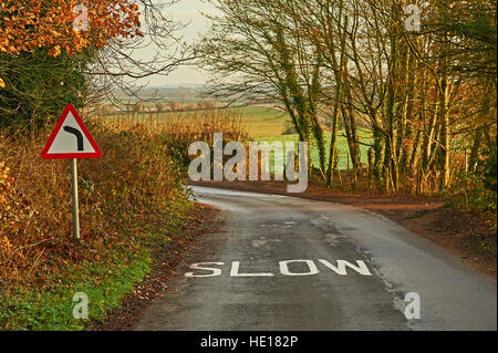 Eine englische Feldweg in der Winterzeit mit einem scharfen Linkskurve Schild Stockfoto