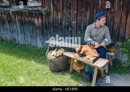 Eine männliche Teenager freiwillige Rolle spielt eine 1600 Siedler in Sainte-Marie unter der Huronen, ein lebendiges Museum in Midland, Kanada. Stockfoto