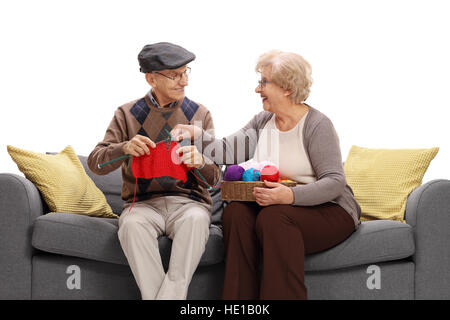 Reife Frau zeigt einem reifen Mann, wie man strickt, isolierten auf weißen Hintergrund Stockfoto