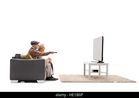 Senioren auf dem Sofa sitzen und Fernsehen mit einer von ihnen hält eine Fernbedienung isoliert auf weißem Hintergrund Stockfoto