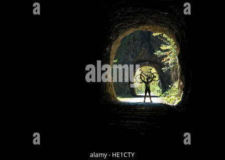 Weibliche Radfahrer hält ihr Fahrrad, Waldbahnstrasse Road, Kalk-Alpen-Nationalpark, Oberösterreich, Österreich Stockfoto