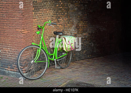 Traditionellen niederländischen grünen Fahrrad mit Zyklus Tasche parkte vor einer Wand Stockfoto