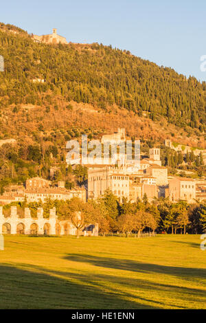 Römische Theater Ruinen in Gubbio mit mittelalterlichen Ortskern hinter auf Mount Ingino, Provinz Perugia, Umbrien, Italien. Stockfoto