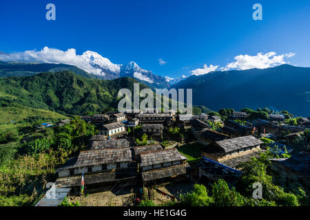 Blick auf das historische Dorf mit den Bergen Annapurna Süd (links), Himchuli (Mitte) und Machapuchare (rechts) in der Ferne Stockfoto